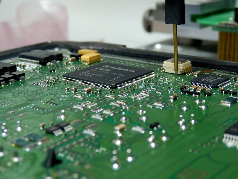 Geöffnetes Motorsteuergerät mit Prüfspitze beim Auslesen der Software